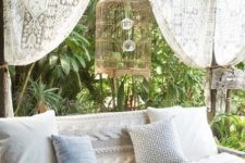 an outdoor sofa covered with a cool crochet patterned piece looks very cozy and very stylish