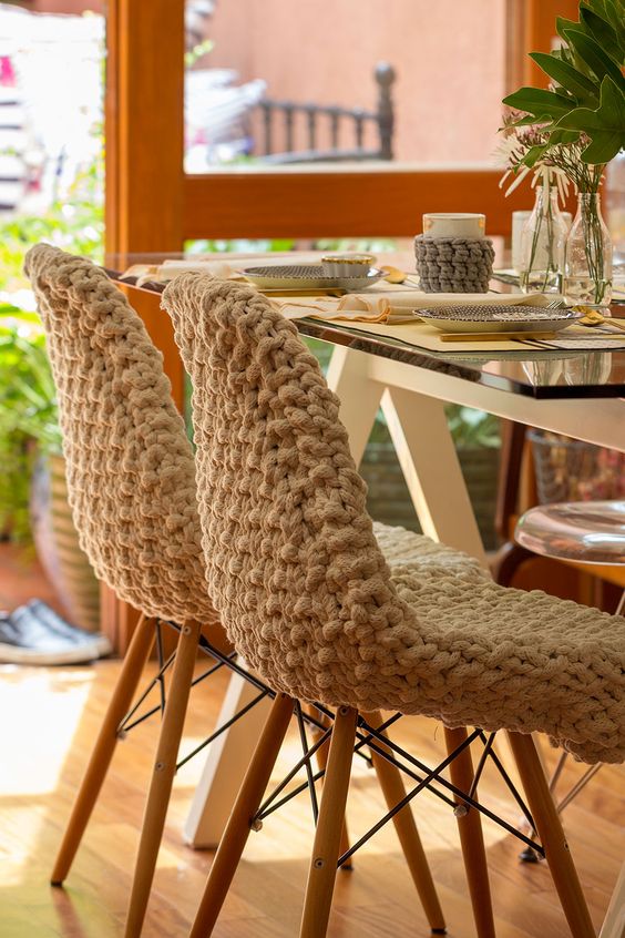 chairs covered with chunky crochet covers are amazing for cozying up the space, add mug cozies in the same style