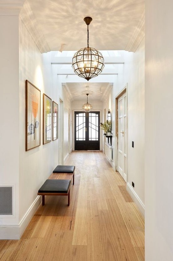 large mid-century modern framed glass pendant lamps bring so much light that two are enough for the whole hallway
