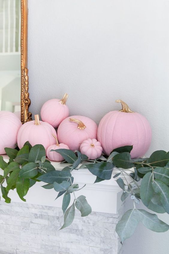 light pink pumpkins with gold stems and fall foliage make the mantel refined and glam