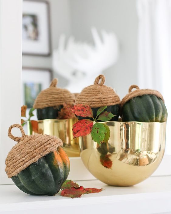a gold polished bowl with gourds turned into oversized acorns using rope is a stylish and quirky centerpiece to rock for Thanksgiving