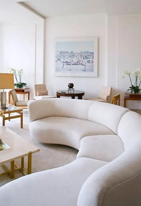 a long rounded creamy sectional sofa adds a whimsy touch to this contemporary space