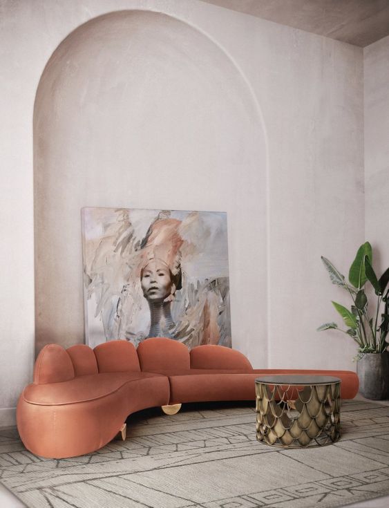 a rust-colored curved low sofa with a creative back and gold legs is a very chic and cool idea for a contemporary and refined space