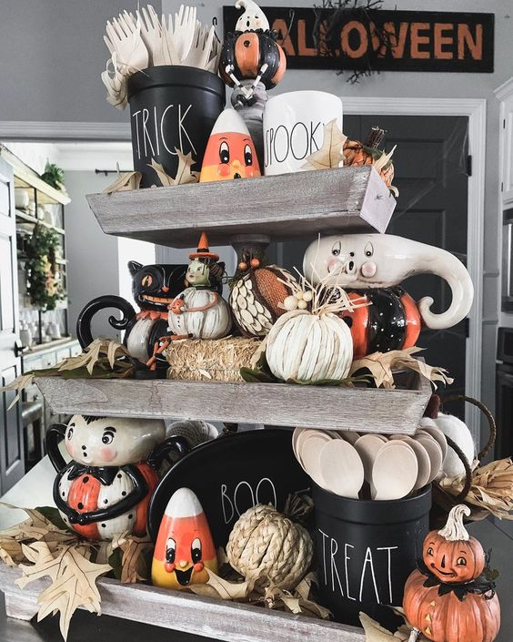 a rustic Halloween stand with hay, pumpkins, husks, vintage toys and fall leaves and other bright stuff
