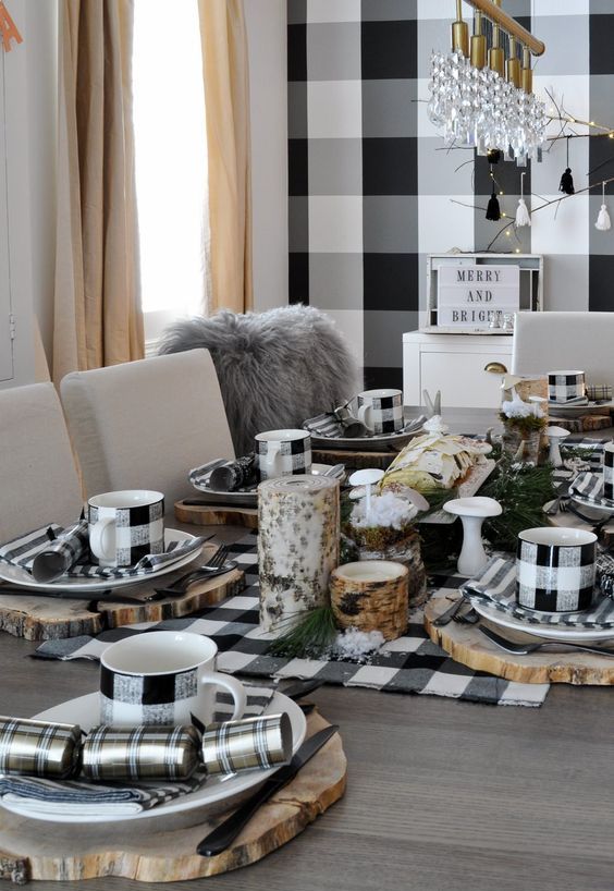 a rustic Thanksgiving tablescape in black and white, with wood slices, buffalo check linens and mugs, greenery