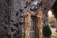 a rustic house entrance with corn husks, pumpkins and bats is a lovely space to enjoy