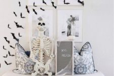 minimalist Halloween decor with black paper bats on the wall and gallery wall, a skeleton, a mini sign is lovely for minimal spaces