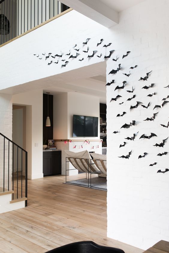 minimalist Halloween decor with black paper bats on the wall is eays to make last minute and looks cool and lovely