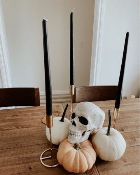 neutral pumpkins and black thin and tall candles in gold candlesticks are cool for minimalist Halloween decor