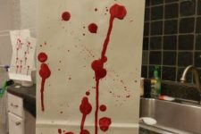 paper with bloody splatters and dripping is a cool and veyr eays way to style your space for a Dexter-themed Halloween party