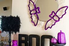 purple Halloween bat silhouettes, feathers, an owl and pumpkins are great for styling your mantel for Halloween