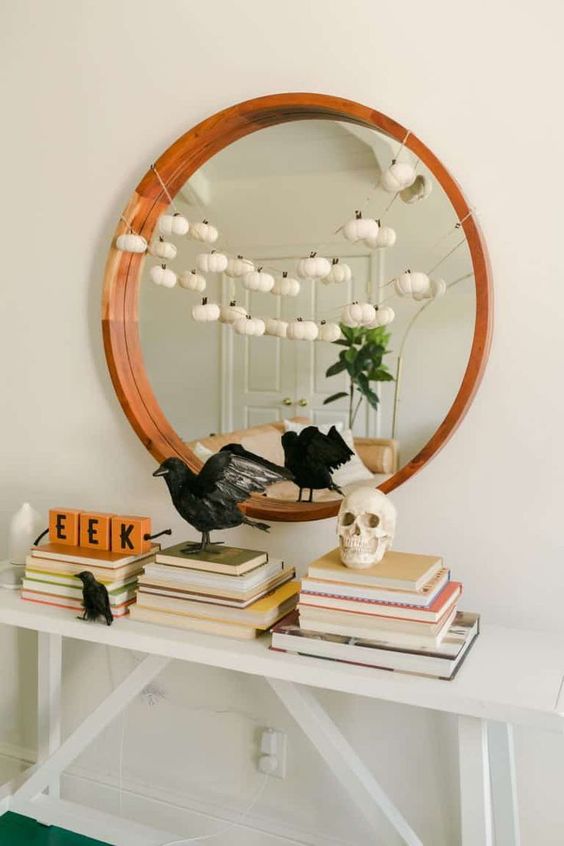 stylish minimalist Halloween decor with blackbirds, a skull and a garland of mini white pumpkins is very chic and cool