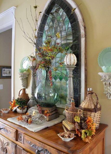vintage rustic Thanksgiving decor with dried leaves, woven bottles, wooden stands with pumpkins, berries and leaves