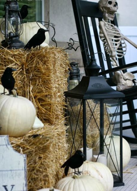 vintage rustic porch styling with a black rocker, a skeleton, hay and pumpkins, candle lanterns and blackbirds is cihc