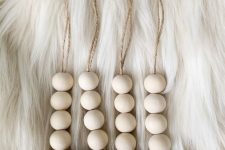 Christmas ornaments of wooden beads and gold bells can be easily DIYed and they look cool
