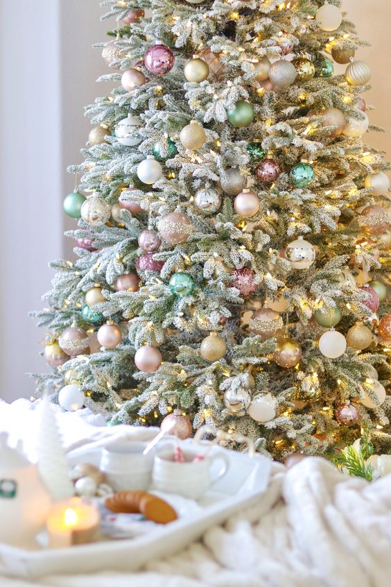 a Christmas tree decorated with blush, pastel pink, green, gold glitter ornaments and lights is a beautiful solution with a soft feel