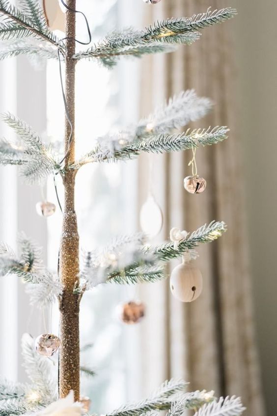 a Christmas tree decorated with white and silver bell ornaments, they bring a shiny and cool touch to the tree