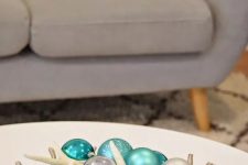 a beach Christmas centerpiece of a silver coral bowl, turquoise and silver ornaments and star fish is a lovely idea
