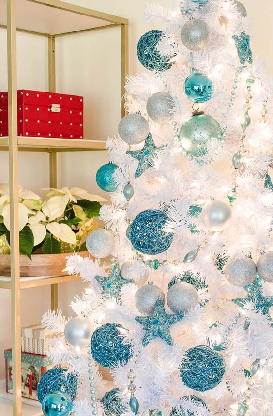 a beautiful beach Christmas tree with white, silver and turquoise ornaments and beads is a gorgeous idea for a coastal Christmas space