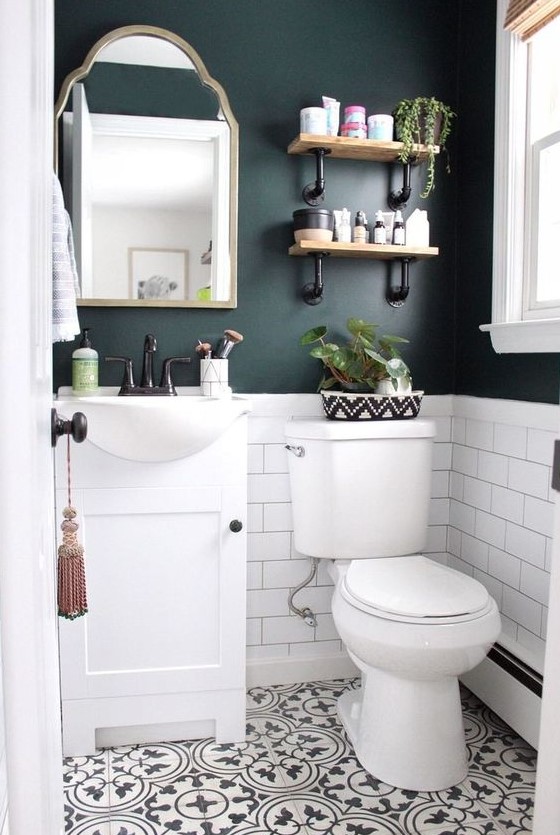 a black and white powder room with black walls, white subway tiles, Moroccan tiles on the floor, a white vanity and white appliances