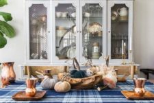 a blue plaid tablecloth and some blue fabric pumpkins make the tablescape more modern and bold