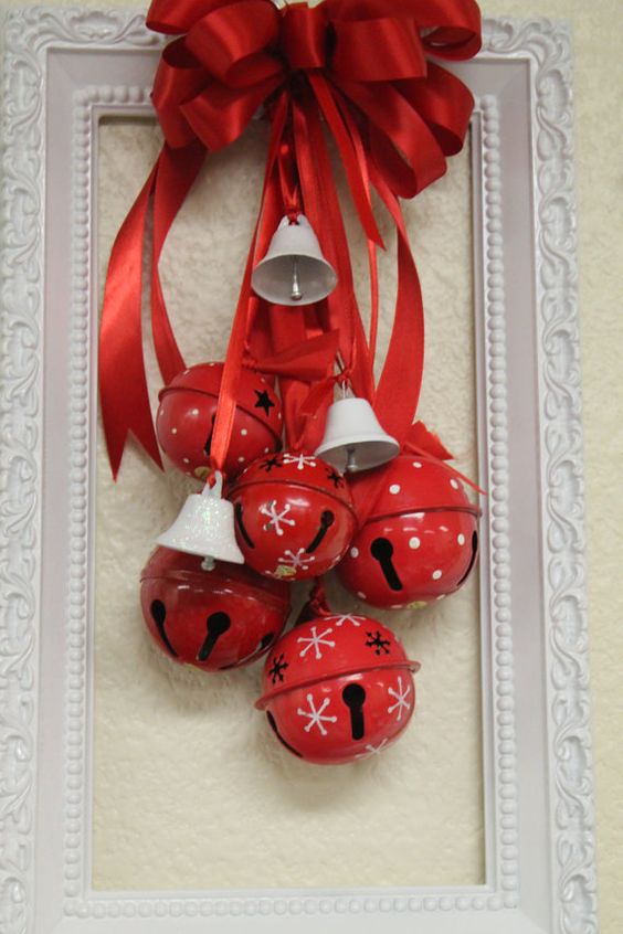 a bold Christmas decoration of a white frame, red Christmas bells and mini white ones, a red bow