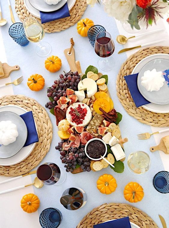 a bright modern Thanksgiving table with orange and blue touches looks super bold and super cool