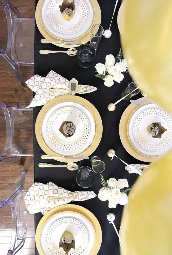 a chic black and gold tablescape with polka dots, geo prints and some white blooms are an amazing combo for NYE