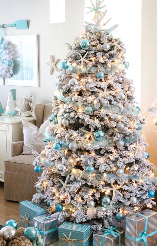 a coastal Christmas tree - a flocked one with silver, light and bright blue ornaments, lights, starfish and a star tree topper is a gorgeous idea