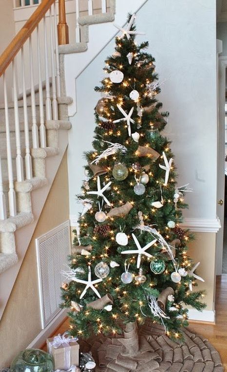 a coastal Christmas tree with lights, pinecones, starfish, buoys, corals is a cool idea for a beach rustic Christmas tree