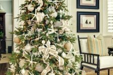 a coastal Christmas tree with starfish, seashells, neutral and metallic ornaments, lights and burlap ribbons