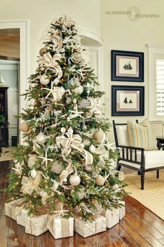a coastal Christmas tree with starfish, seashells, neutral and metallic ornaments, lights and burlap ribbons