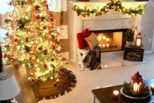 a cozy Christmas living room with a fir garland with lights, bright mini trees, a red lantern, a Christmas tree with lights, red ribbons, pinecones and red ornaments