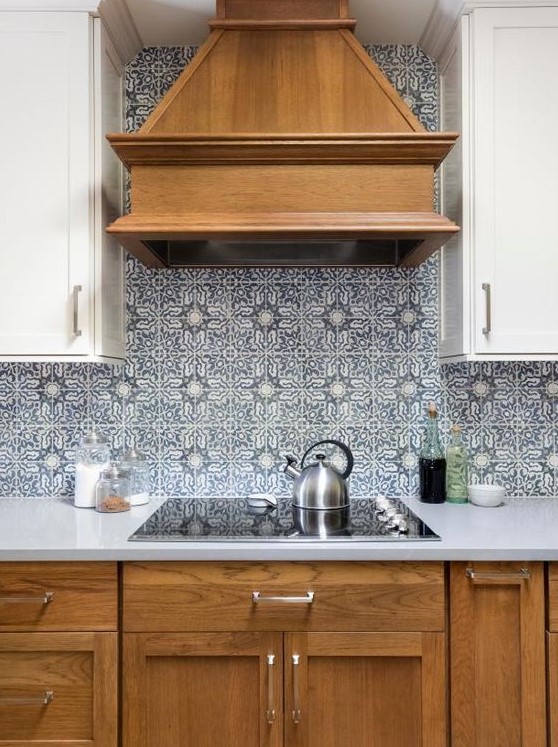 a cozy kitchen with stained and white cabinets, blue Moroccan tiles on the backsplash, white countertops is a chic idea