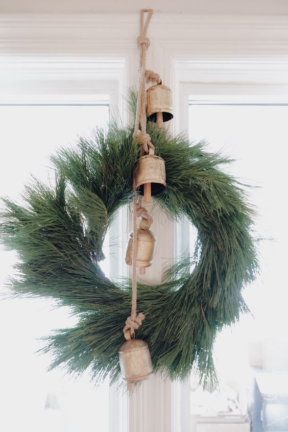 a fir wreath with large vintage bells is a lovely and bold Christmas decor idea with a wild touch