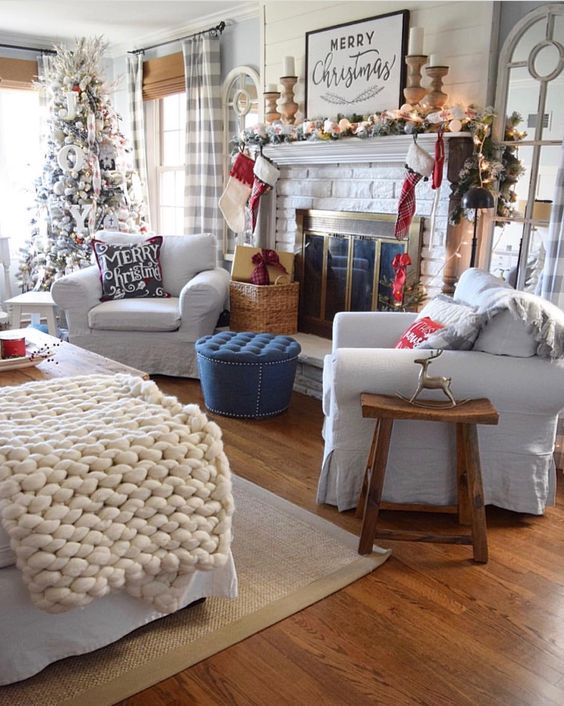 a flocked fir garland, candles in wooden candleholders, printed sotckings, a flocked Christmas tree with letters and ribbons