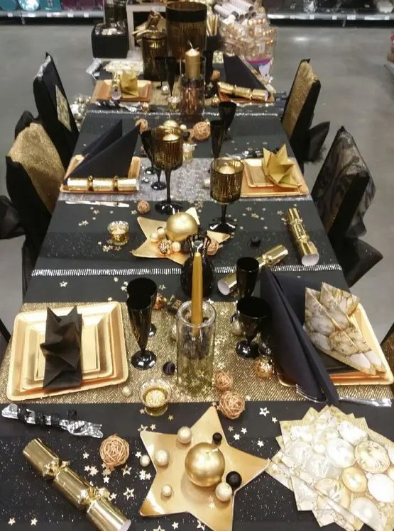 a fun black and gold tablescape with stars, stripes and candles is amazing for a New Year's Eve