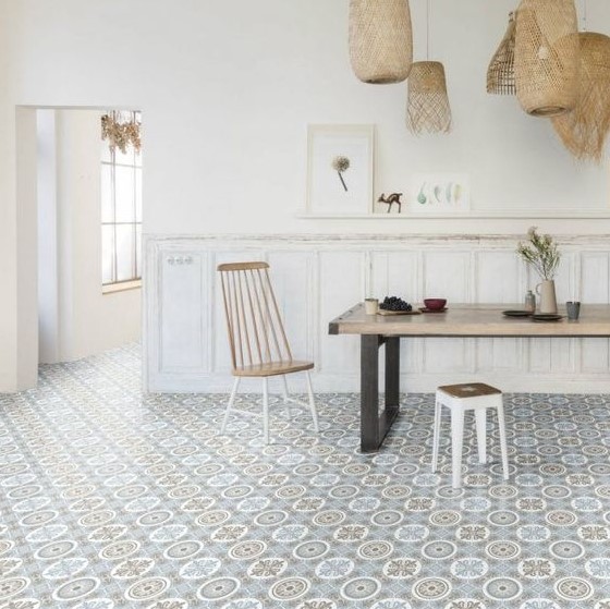 a laid-back dining room with white panels on the walls, a Moroccan tile floor, a dining table, cool chairs and woven pendant lamps
