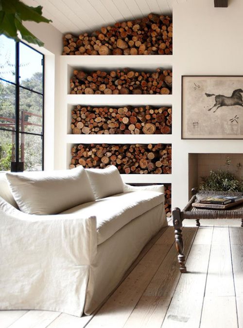 a non-working fireplace and an open storage unit with firewood make this Provence room cozy and welcoming