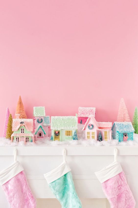 a pastel Christmas mantel with lovely faux fur stockings, pastel mini houses, faux snow and shiny Christmas trees