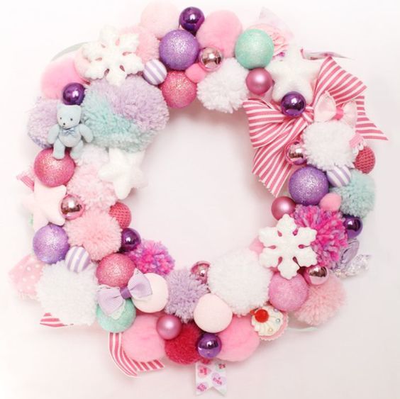 a pastel Christmas wreath of pompoms and ornaments, stars and snowflakes and striped ribbons is a pretty decoration