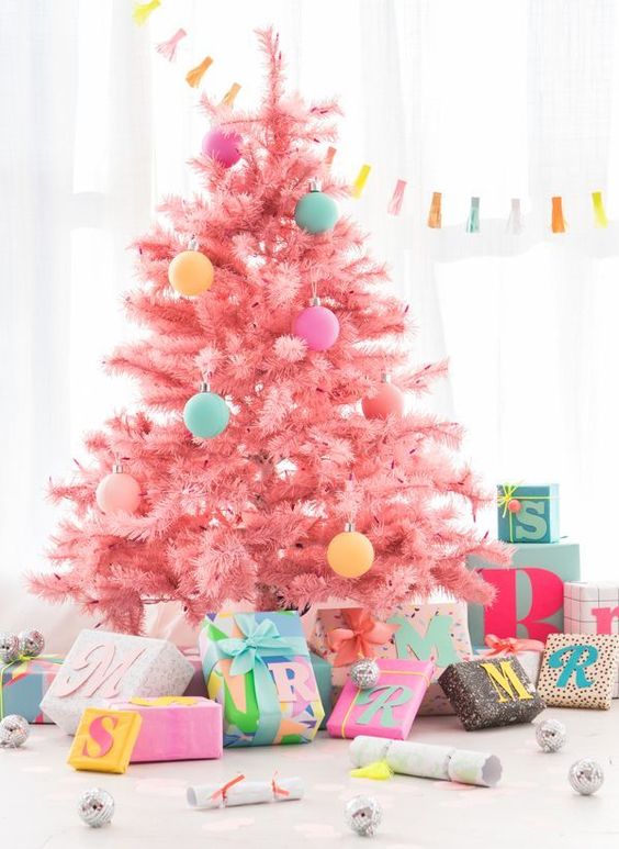 a pastel pink Christmas tree decorated with pastel pink, yellow, aqua and purple ornaments is a very cute and sweet idea
