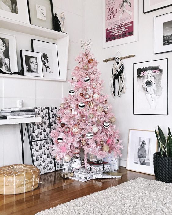 a pastel pink Christmas tree decorated with striped black and white, blush, gold glitter and brown ornaments is a lovely idea for any space