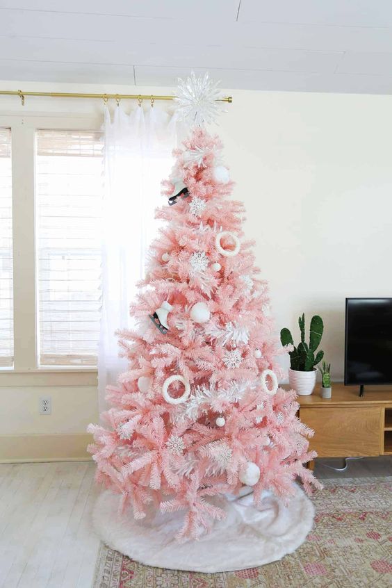 a pastel pink Christmas tree with skate and donut ornaments, pompoms and a shiny snowflake tree topper is amazing