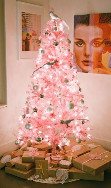 a pastel pink Christmas tree with white and metallic ornaments and quirky birdie ornaments plus lights