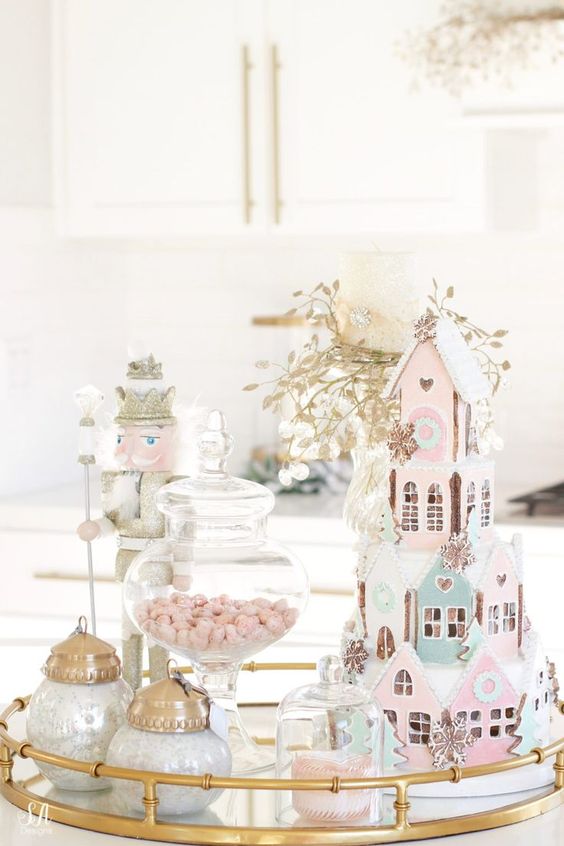 a pastel sweets table with pink and blue houses, pink candies in jars and touches of gold for a shiny look
