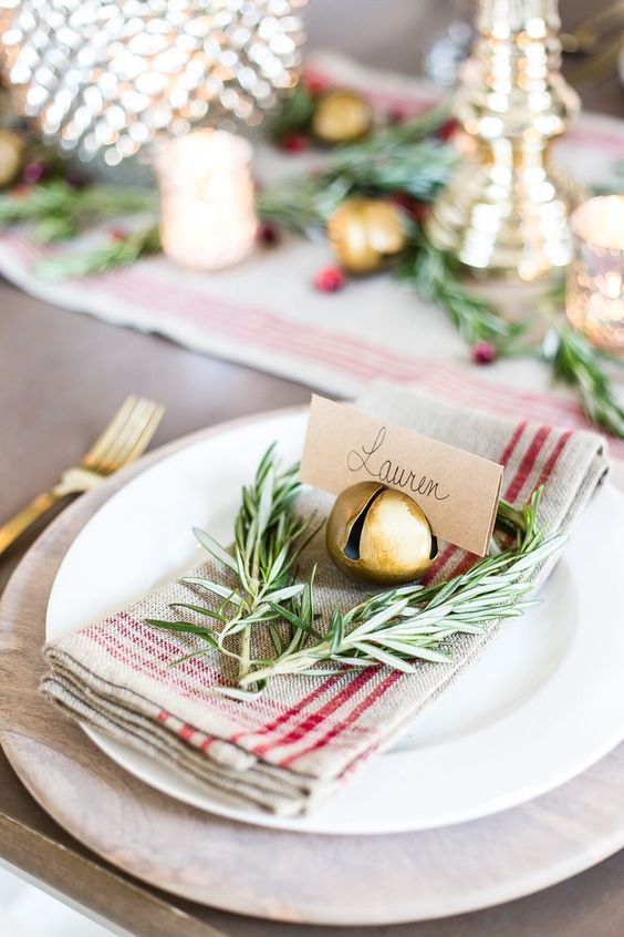 a rustic Christmas place setting with a striped napkin, twigs, a bell that holds a card is amazing for holidays
