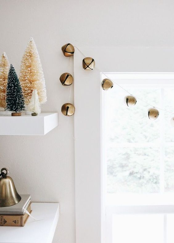 a simple garland of gold Christmas bells is a lovely and chic idea that will easily bring festive spirit to the space