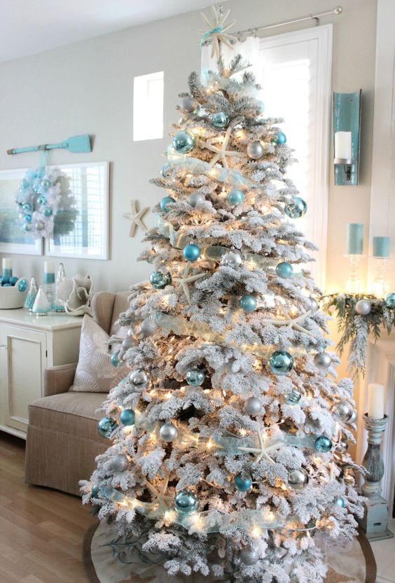 a sophisticated flocked Christmas tree with mint, aqua, silver, white ornaments, ribbons, lights, starfish is very chic