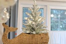 a whale basket with a small flocked Christmas tree with lights is a lovely beach or coastal Christmas decoration